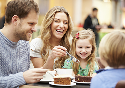 Family Enjoying Snack In Café Together