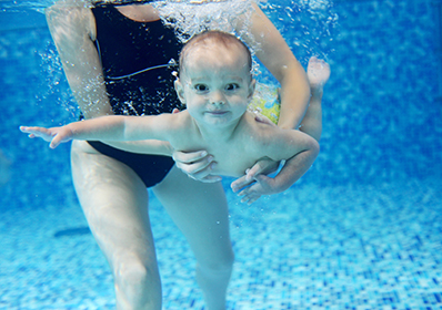 Little,Boy,Learning,To,Swim,In,A,Swimming,Pool,,Mother
